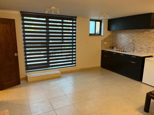 a kitchen with a large window with wooden blinds at סוויטה במושב פסטורלי רומנטי ושקט in Gannot Hadar
