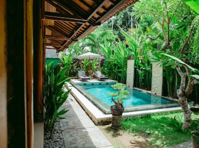 a house with a swimming pool in a garden at Kinton Guesthouse in Nusa Penida