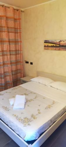 Una cama con dos toallas en una habitación en T'Addormento en Reggio Calabria