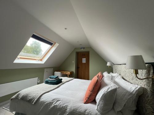 a attic bedroom with a bed with a window at Cotswold Retreat - Private & Peaceful 