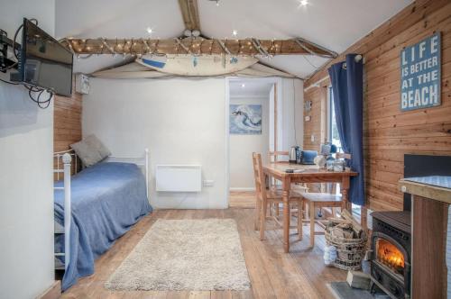 a bedroom with a bed and a desk and a table at The Lodge - 1 Bedroom - Freshwest Beach Retreat in Pembroke