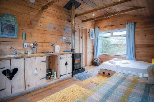 a kitchen with wooden walls and a large window at The Hygge Hut - 1 Bed - Freshwest Beach Retreat in Pembroke