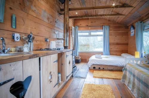 a log cabin kitchen with a bed and a sink at The Hygge Hut - 1 Bed - Freshwest Beach Retreat in Pembroke