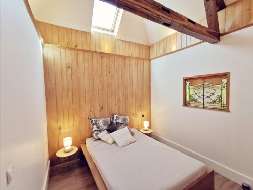 une chambre avec un lit avec des murs en bois et une fenêtre dans l'établissement Maison Vanier - Duplex - centre-ville - Mon Groom, à Troyes