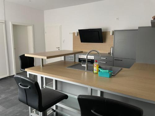 an office with a desk with a sink and two chairs at M&M Apartment Düsseldorf in Neuss