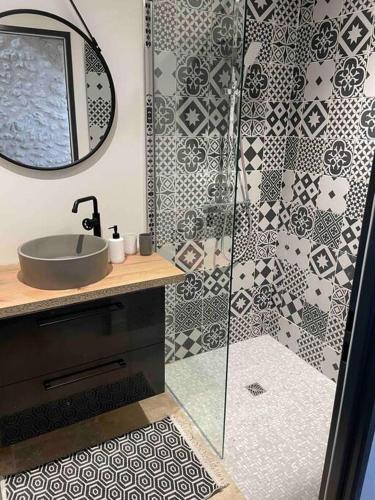 une salle de bain avec une douche avec un lavabo et un miroir dans l'établissement Cottage paisible, à Ribérac