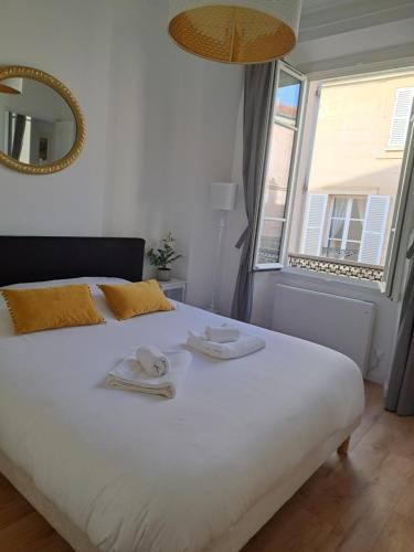 a bedroom with a large white bed with towels on it at Agréable 2 pièces - rue du vieux Versailles in Versailles