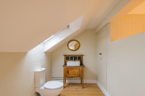 ein Badezimmer mit einem weißen WC und einem Spiegel in der Unterkunft Shell Seekers Cottage in Deal