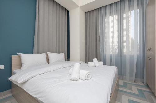 a bedroom with a white bed with towels on it at Hotel Armeni in Yerevan