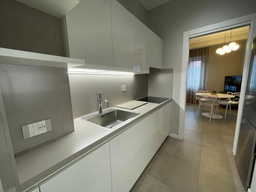 a white kitchen with a sink and a table at Domus Pyrus Apartments in Pero