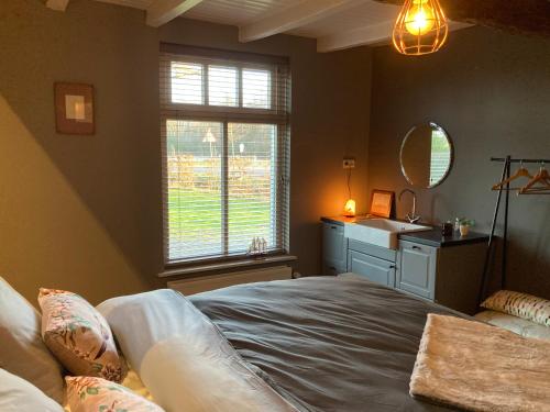 a bedroom with a large bed and a sink at Hoeve bij Vosselen in Asten