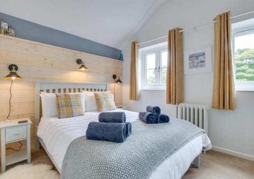 a bedroom with a bed with blue towels on it at Pendeen Hayloft in Saint Stephen