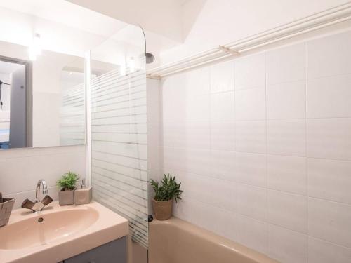 a bathroom with a tub and a sink and a mirror at Appartement Saint-Lary-Soulan, 2 pièces, 4 personnes - FR-1-296-239 in Saint-Lary-Soulan