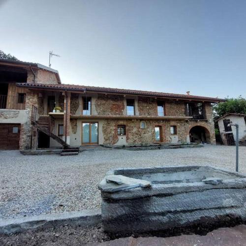 a large brick building with a large tub in front of it at Istanti - Menta in Costigliole Saluzzo