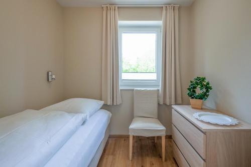 Un dormitorio con una cama, una silla y una ventana en Wolke 7, en Husum