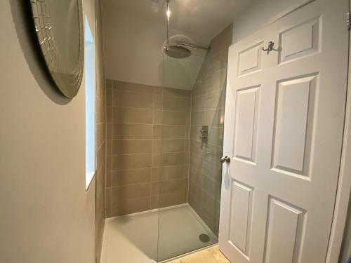 a bathroom with a shower with a glass door at Cotswold Retreat - Private & Peaceful 