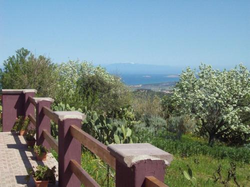 a wooden fence with a view of the ocean at Villa Veronica in Sedini