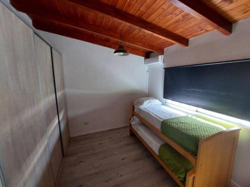 um pequeno quarto com uma cama no canto em Casa en Funes. Pileta, Parrilla & Parque. em Funes