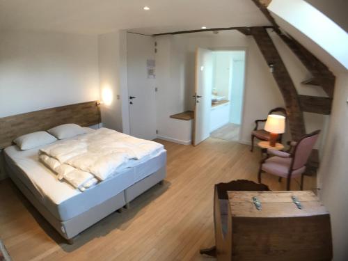 a bedroom with a bed and a table and a chair at le Moulin de Braives in Braives