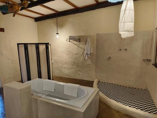 a bathroom with a bath tub and a sink at Dar Amane Guest House in Graskop