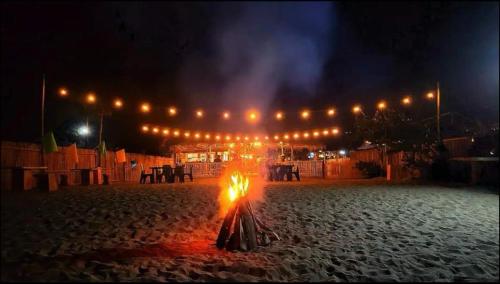 una hoguera en medio de una playa por la noche en Cabin in San Narciso, en San Narciso
