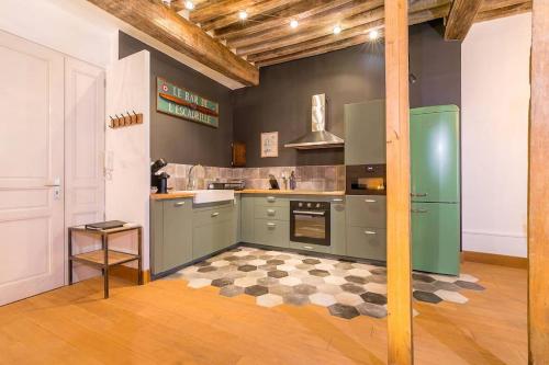 La cuisine est équipée d'un réfrigérateur vert et d'un sol en damier. dans l'établissement L'Escale, à Dijon