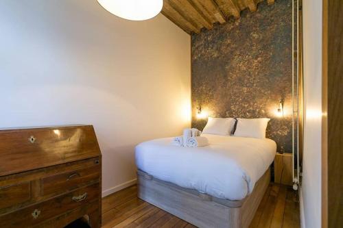 a small bedroom with a bed and a dresser at L'Escale in Dijon