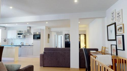 a living room with a couch and a kitchen at COLMARAPPART Grand'Rue in Colmar