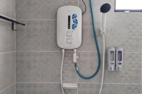 a remote control on the wall of a shower at Mutiara Melaka Beach Resort by Ally 