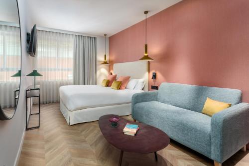 a hotel room with a couch and a bed at Aparthotel Tribunal in Madrid