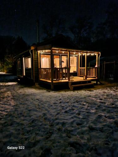eine kleine Hütte mit nachts eingeschaltetem Licht in der Unterkunft Huys de Landerije in Wouwsche Plantage