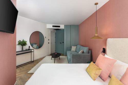 um quarto com uma cama e uma sala de estar em Aparthotel Tribunal em Madrid