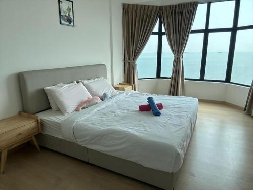 a bedroom with a bed with two toys on it at Mutiara Melaka Beach Resort by Ally in Kampong Pengkalan Lanjut