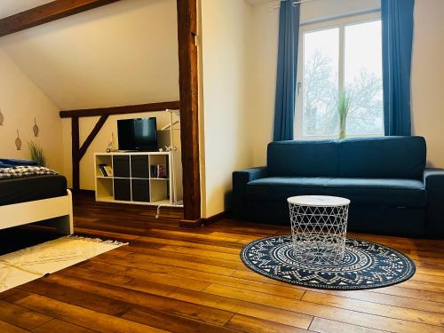 a living room with a blue couch and a table at Kapitänshaus an der Warnow mit Sauna in Rostock