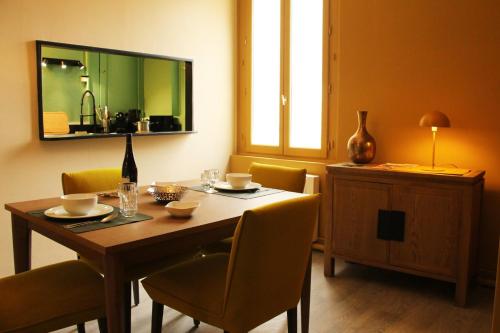 een eetkamer met een tafel en stoelen en een spiegel bij Picassiette in Chartres