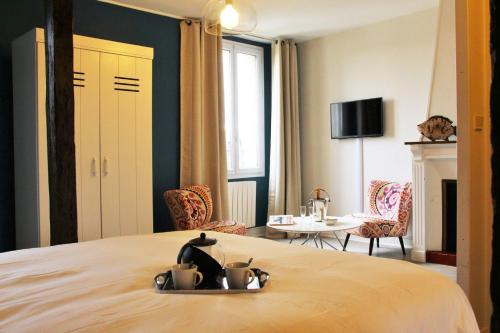 une chambre d'hôtel avec un lit, une table et des chaises dans l'établissement Picassiette, à Chartres
