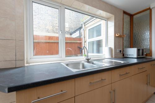 a kitchen with a sink and a window at 4 BED House IN Dartford 8 Beds Sleeps 10 in Kent