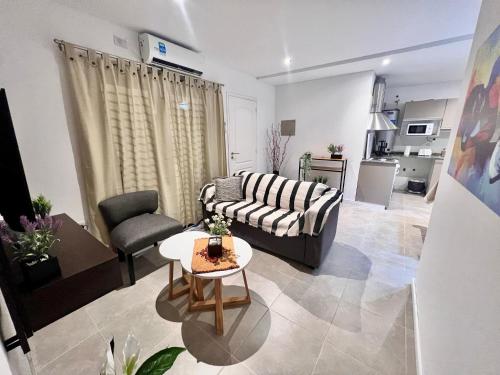 sala de estar con sofá y mesa en Lumiere apartments 5- Departamento en complejo residencial en El Challao