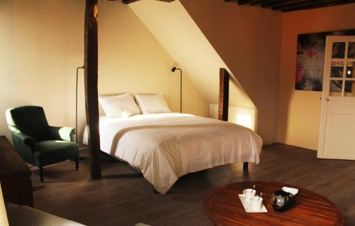 - une chambre avec un lit, une chaise et une table dans l'établissement Fulbert - view on Cathedral and Place des Epars, à Chartres