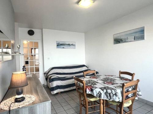 Cette chambre comprend une table et un lit. dans l'établissement 514 - Appartement 1 chambre vue mer en bordure de la plage du centre d'Erquy, à Erquy
