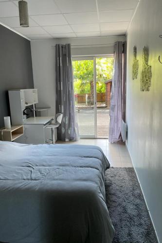 une chambre avec un lit, un bureau et une fenêtre dans l'établissement La musette du Tarn, à Mostuéjouls