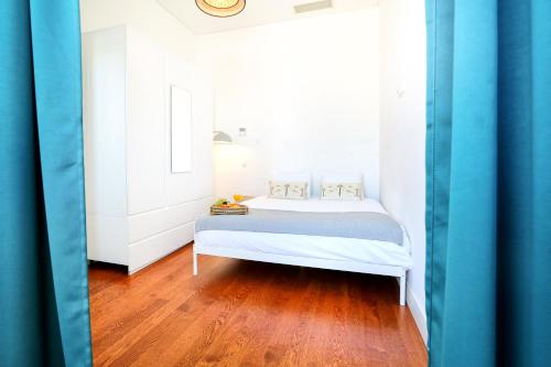 a bedroom with a white bed and a wooden floor at Lovely Faro Apartment in Faro