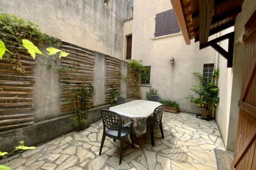 een tafel en stoelen op een patio bij Villa Isabelle- Large bright house with courtyard! in Mudaison
