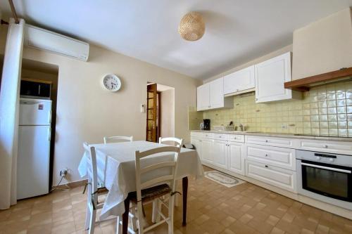 een keuken met een tafel en witte kasten bij Villa Isabelle- Large bright house with courtyard! in Mudaison