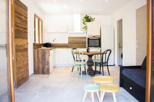 un salon avec une table et des chaises et une cuisine dans l'établissement Location Casa Di Lesia à Sotta / Porto-Vecchio, à Sotta