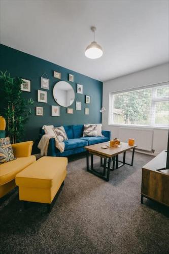 a living room with a blue couch and a table at Sapphire Lodge-Wyndale-WContractors Parking in Birmingham