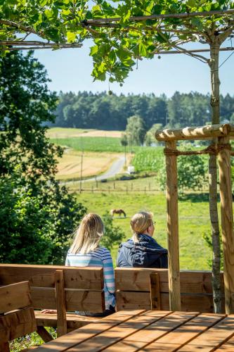 two people sitting on a bench looking at a field at Landhotel Buller in Hagen