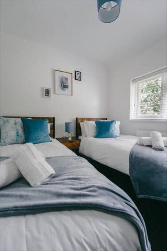 um quarto com 2 camas e almofadas azuis em Sapphire Lodge-Wyndale-WContractors Parking em Birmingham