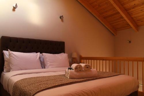 a bedroom with a large bed with two towels on it at Δρυάδες Suites in Arachova