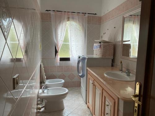 ein Bad mit einem WC und einem Waschbecken in der Unterkunft Il belvedere in Budoni